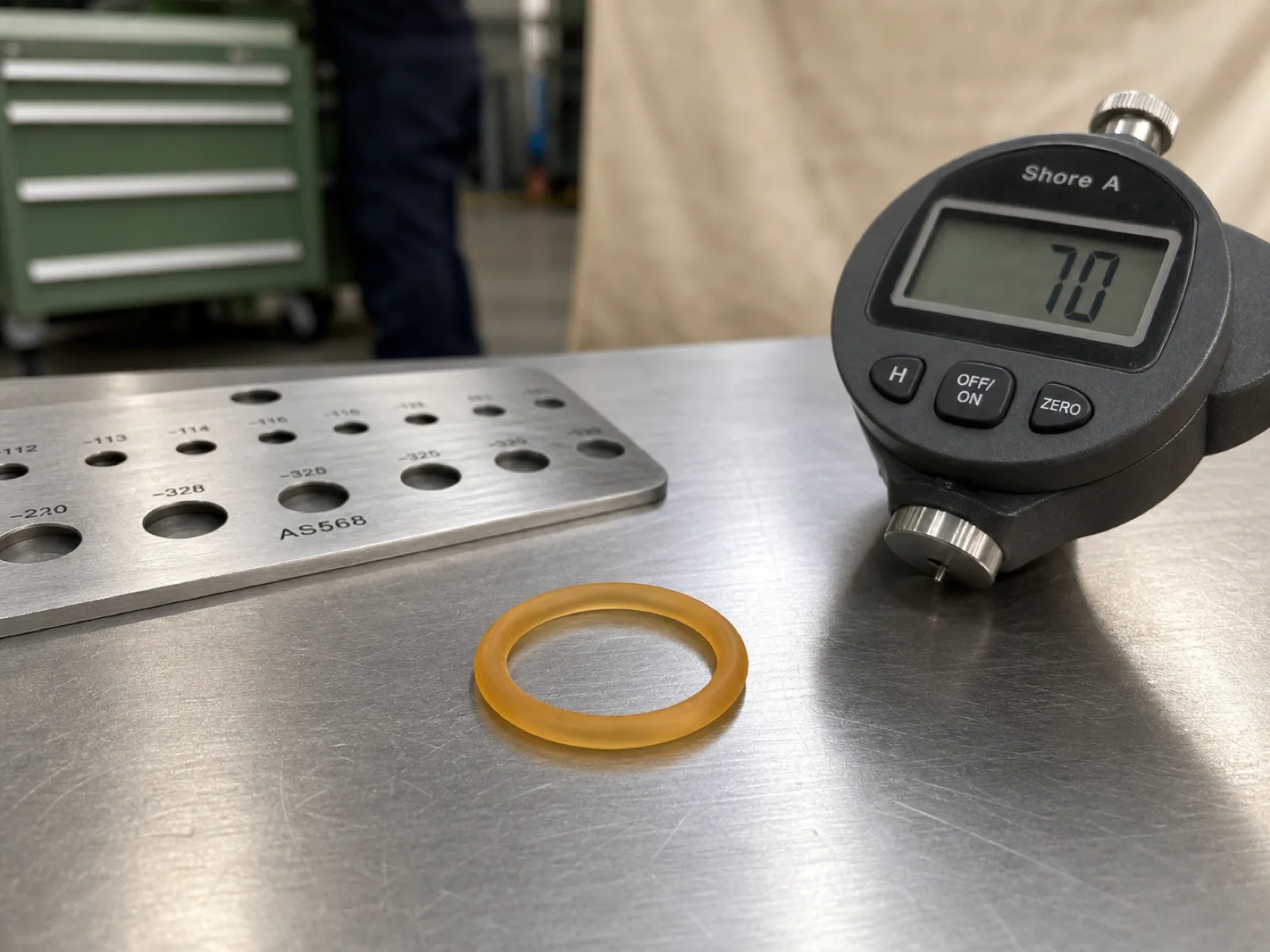 Translucent 70 Shore A high-temperature silicone VMQ o-ring cross-section on a QC bench beside a durometer and AS568 gauge under D65 workshop lighting for high-temperature silicone o-ring OEM guide.