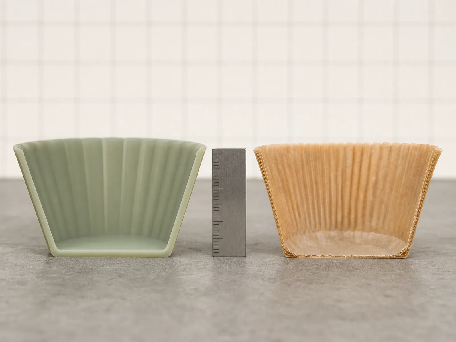 Rows of platinum-cured silicone baking cups on a QC bench with calipers and a durometer, workshop lighting on cream-and-sage palette