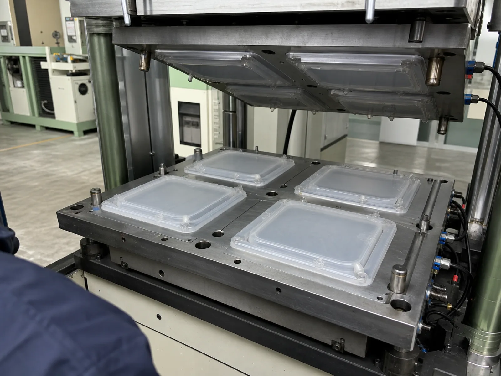Wetop Silicone compression molding press mid-cycle running a 4-cavity platinum-cure LSR tool producing silicone food storage bag shells with integrated slider zipper at 180°C in Dongguan