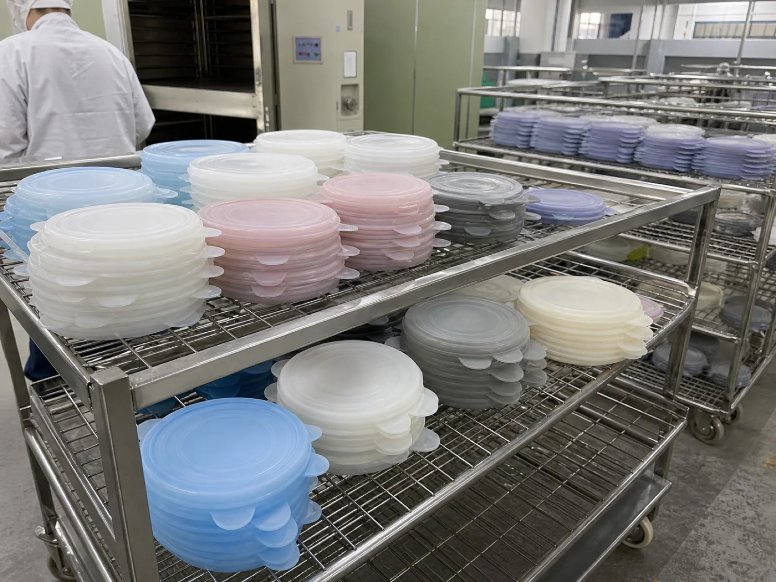 Wetop Silicone post-cure and secondary-process workshop with batches of silicone stretch lids on inspection racks after the mandatory 4-6 hour cycle at 180-200°C in Dongguan
