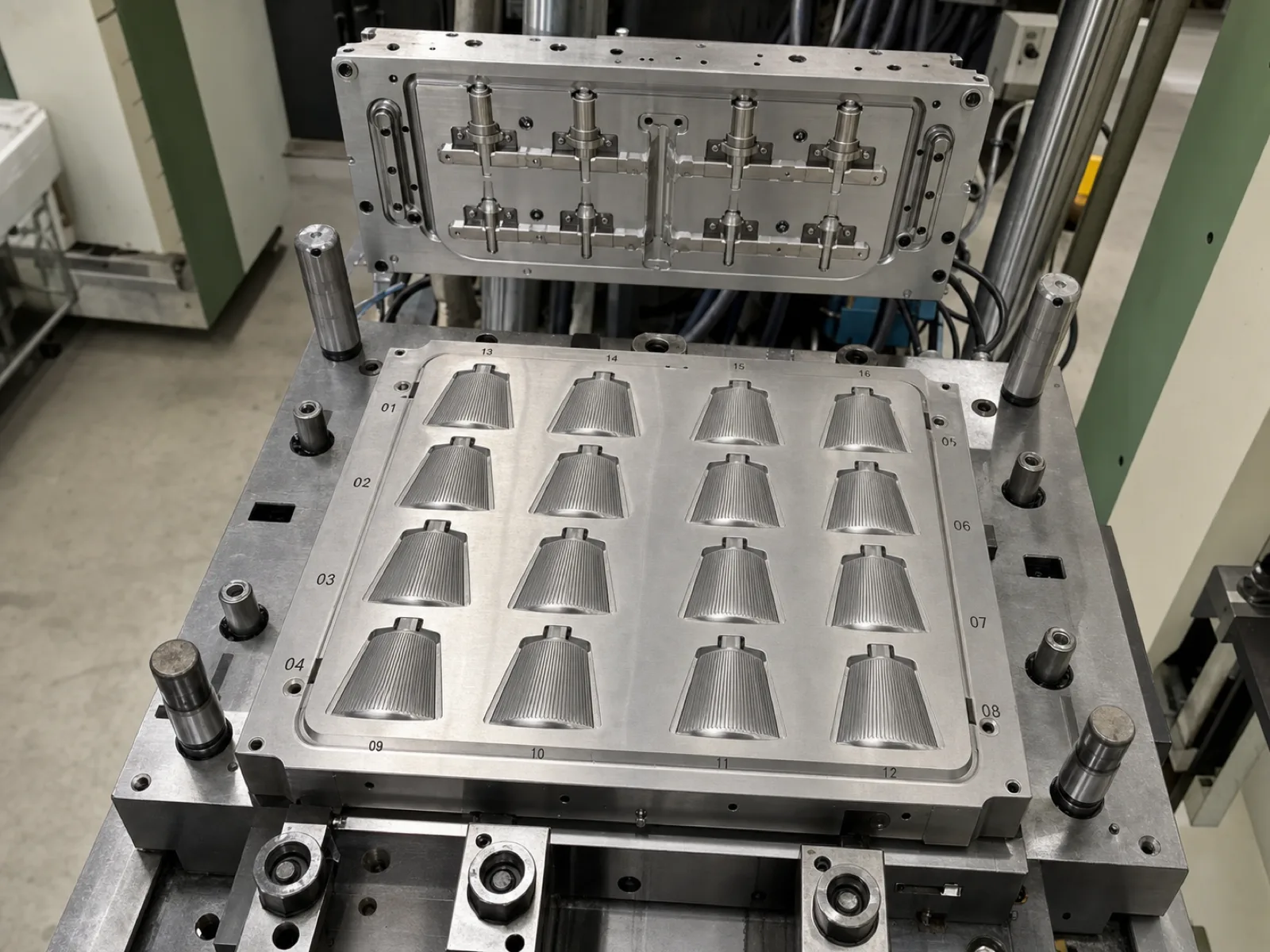 Multi-cavity LSR injection mold for silicone makeup brush heads on a Wetop press bed — a polished steel mold showing sixteen tapered bristle-head cavities in a grid, fine bristle-row detail engraved into each cavity face, etched cavity ID numbers at the edge for QC traceability, a cold-runner manifold plate above.